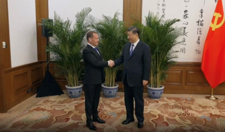 握手するロシアのメドベージェフ前大統領（左）と、中国の習近平・国家主席/Telegram