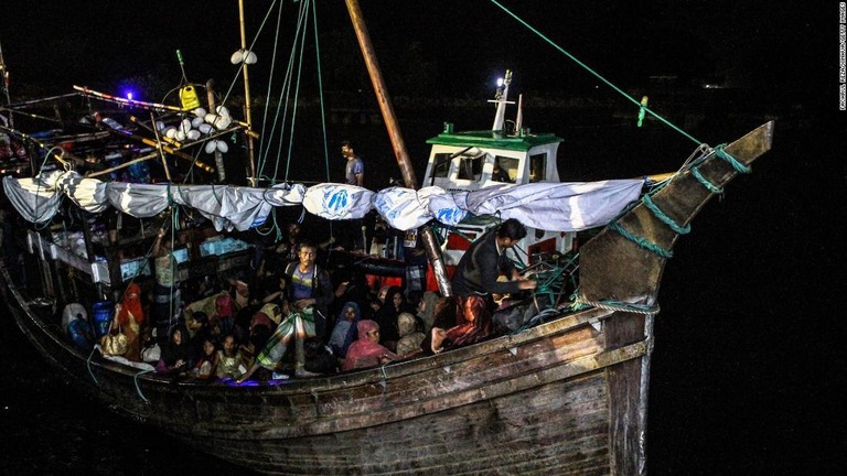 木製の船に座ったロヒンギャ難民＝２０２１年１２月３１日、インドネシア・アチェ州の港/Fachrul Reza/Xinhua/Getty Images