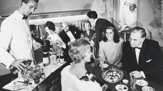盛装して飲食を楽しむ１９５８年のルフトハンザ航空ファーストクラスの乗客ら