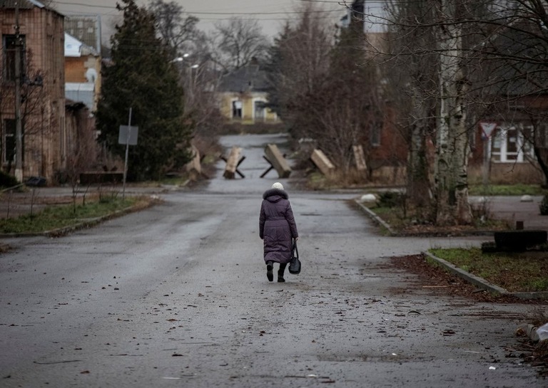 ウクライナ東部ドネツク州バフムートの道路をただ一人歩く人＝１２月１８日撮影/Oleksandr Ratushniak/Reuters
