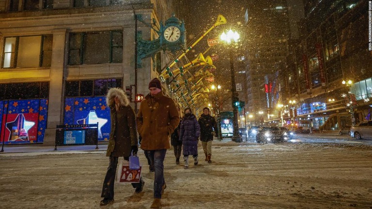 雪の降りしきる中、道路を渡る歩行者＝米イリノイ州シカゴ/Kamil Krzaczynski/AFP/Getty Images