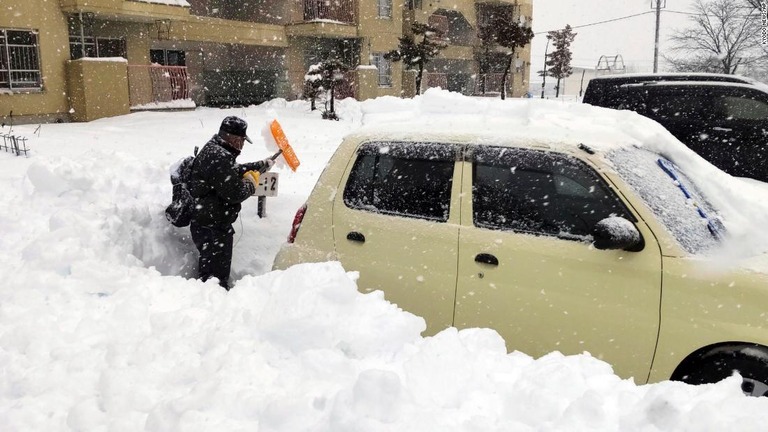 雪かきをする男性＝２４日、北海道/Kyodo News/AP