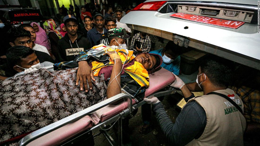 避難所に向かうロヒンギャの女性を救急車に乗せるボランティアと兵士ら=26日、インドネシア・アチェ州/Amanda Jufrian/AFP/Getty Images
