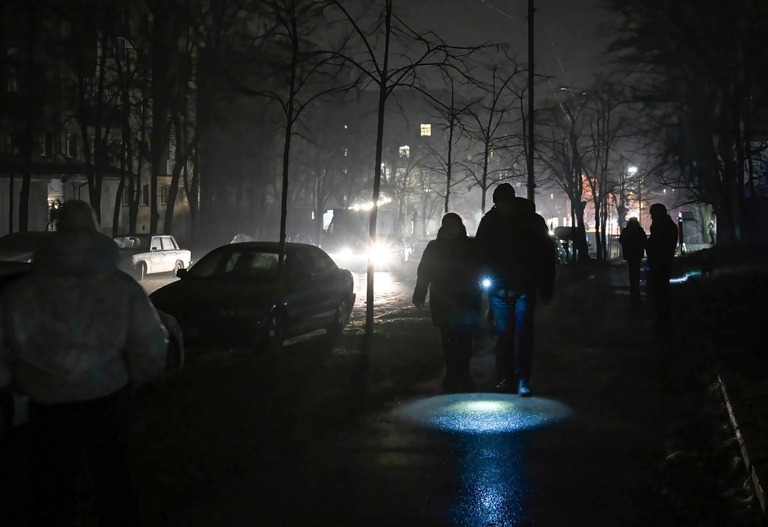 停電中のウクライナ首都キーウで懐中電灯を手に歩く人々＝１２月２４日撮影/Sergei Chuzavkov/SOPPA Images/Sipa USA/AP
