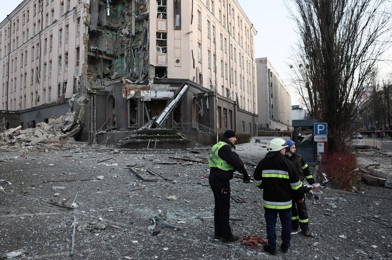 ロシア軍のミサイルで破壊された建物の前で作業する救急要員/Gleb Garanich/Reuters