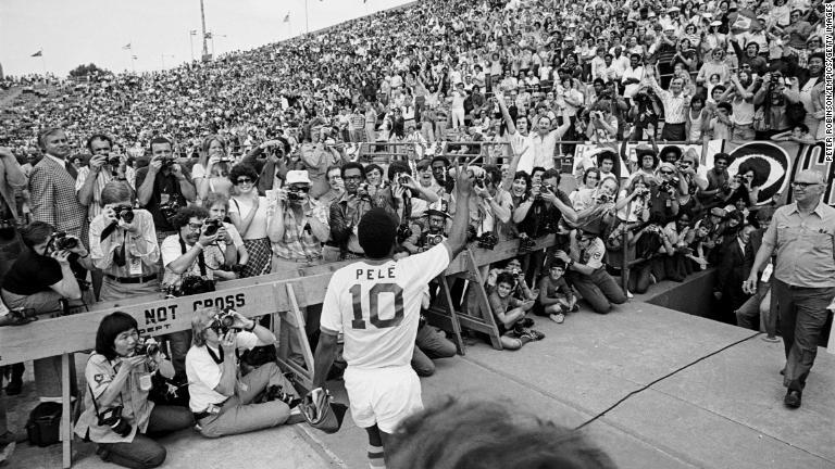 1975年、ニューヨーク・コスモスでのデビュー戦の前にファンに手を振る/Peter Robinson/EMPICS/Getty Images