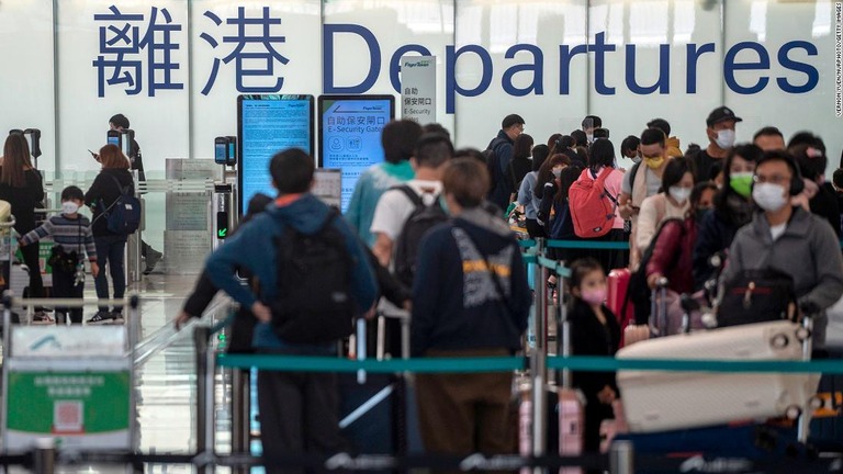 チェックインの列に並ぶ旅行客＝２０２２年１２月２０日、香港国際空港/Vernon Yuen/NurPhoto/Getty Images