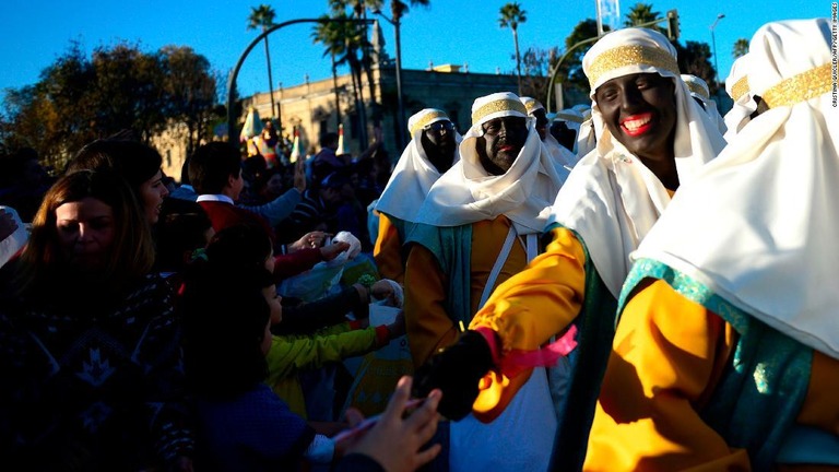 バルタザールをまねて黒塗りの顔でパレードに参加する人々/Cristina Quicler/AFP/Getty Images