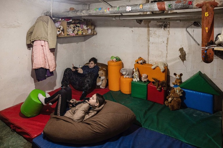 避難所として使われている地下室でテレビを見る子どもたち＝２０２２年１２月、ウクライナ・バフムート/Sameer Al-Doumy/AFP/Getty Images