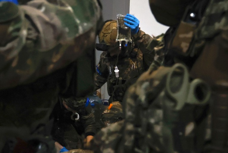 負傷した兵士に応急処置を施すウクライナ兵＝８日、ウクライナ東部ドネツク州のソレダル/Roman Chop/AP