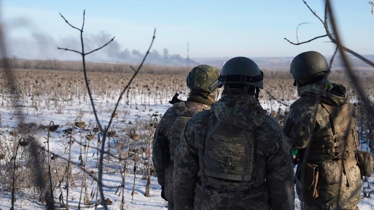 ソレダルで戦闘中に立ち上る煙を眺めるウクライナ軍の兵士ら/Libkos/AP