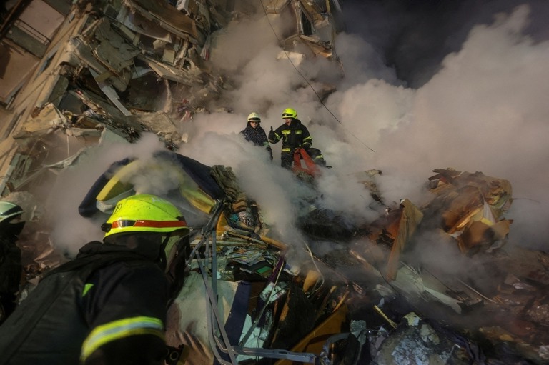 損傷した建物で捜索を行う救急隊＝１４日、ウクライナ・ドニプロ/Yevhen Titov/Reuters