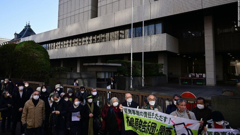 裁判所前で集会に参加する原告団の関係者ら＝１８日/Philip Fong/AFP/Getty Images