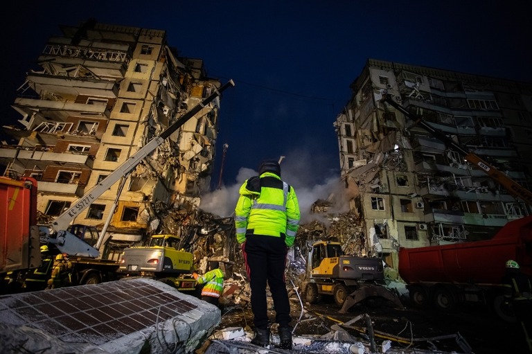 ミサイルで破壊された集合住宅を見つめる隊員＝１５日/Yevhenii Zavhorodnii/Global Images Ukraine/Getty Images