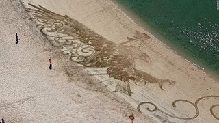 海岸の波打ち際近くに描かれた砂絵