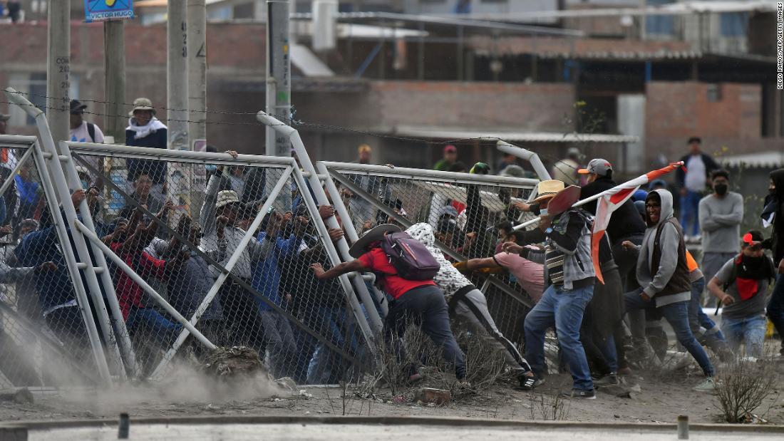 アレキパの空港に立ち入ろうとフェンスを倒すデモ参加者ら/Diego Ramos/AFP/Getty Images