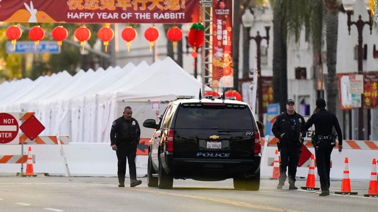 銃乱射事件が発生したダンススタジオ前に立つ警察官ら＝２２日、米ロサンゼルス近郊モントレーパーク/Jae C. Hong/AP