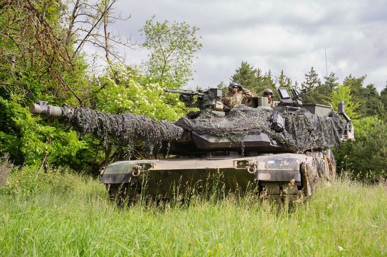 訓練中に森林地帯でエイブラムス戦車に乗る米軍兵＝２２年６月、ドイツ/Nicolas Armer/dpa/Getty Images