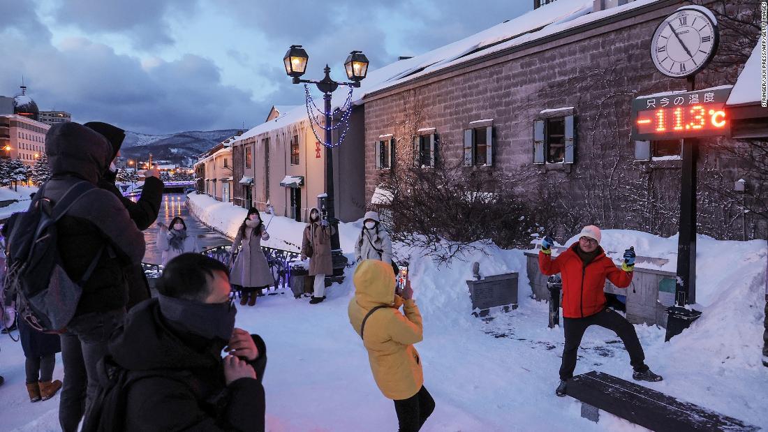 北海道の小樽では温度計の表示の前で記念撮影＝２４日/Stringer/JIJI Press/AFP/Getty Images