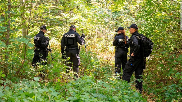 昨年８月、女性の遺体が見つかった車の付近を捜索するドイツの警察官/Peter Kneffel/dpa/picture alliance/AP/FILE