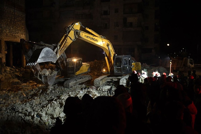シリア・アレッポの倒壊した建物で捜索活動を行う救急隊員ら/AFP/Getty Images