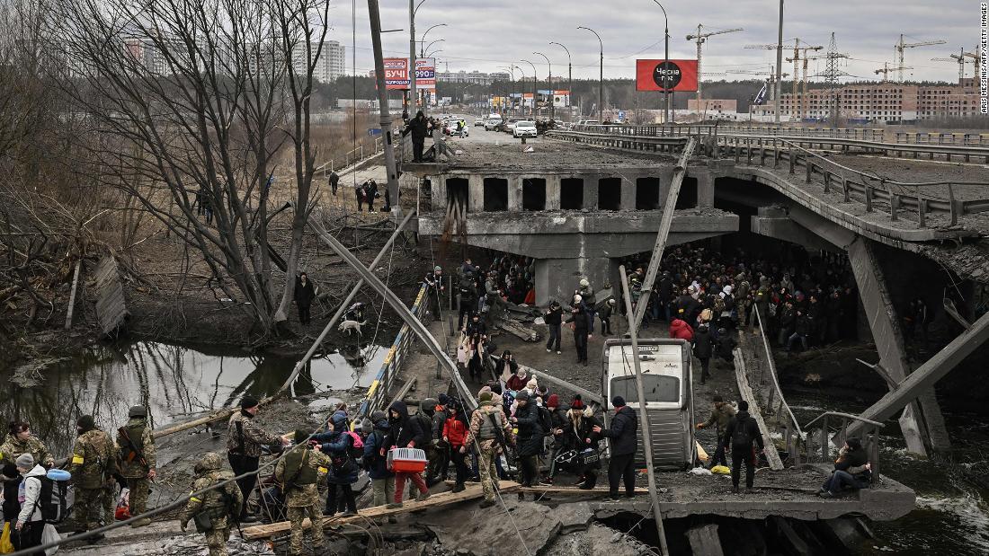 壊れた橋を通ってキーウ（キエフ）近郊のイルピンから避難する住民/Aris Messinis/AFP/Getty Images