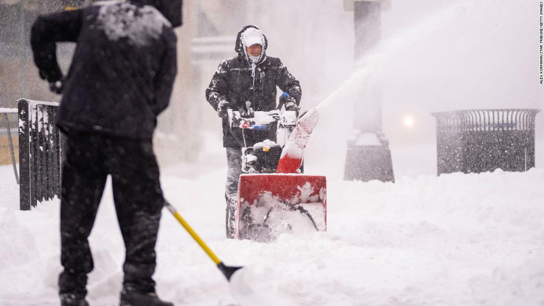 歩道の除雪を行う人々＝２３日、米ミネソタ州ミネアポリス/Alex Kormann/Star Tribune/Getty Images