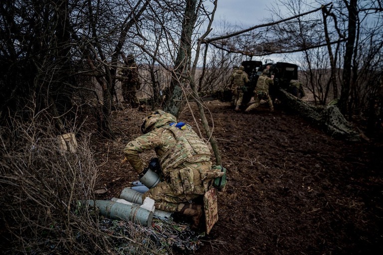 バフムート前線付近でロシア軍に向けて榴弾砲を発射しようとするウクライナ軍の兵士/Dimitar Dilkoff/AFP via Getty Images
