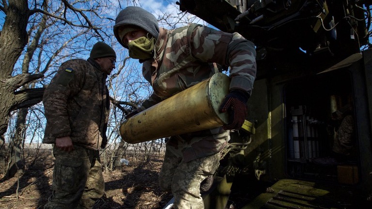 榴弾砲の弾薬を運ぶウクライナ軍兵士＝５日、ウクライナ・バフムート郊外/Anna Kudriavtseva/Reuters