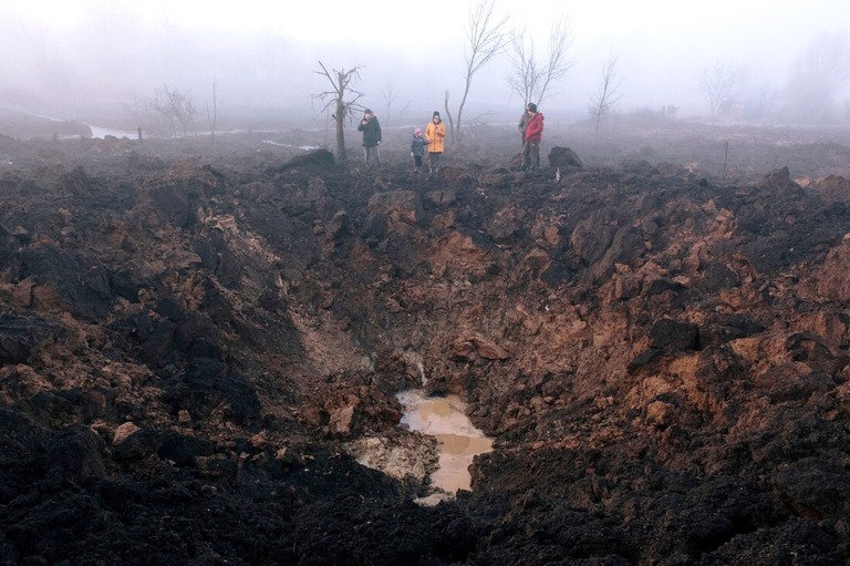 砲撃でできた穴の周囲に集まる地元住民＝９日、ウクライナ・ハルキウ郊外/Pavlo Pakhomenko/EPA-EFE/Shutterstock