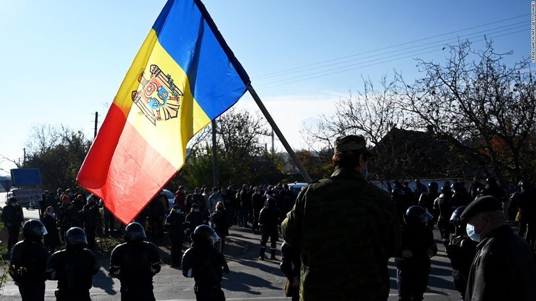大統領選の期間中、特殊警察の要員がモルドバ国旗を掲げて町をパトロールする様子/Sergei Gapon/AFP/Getty Images