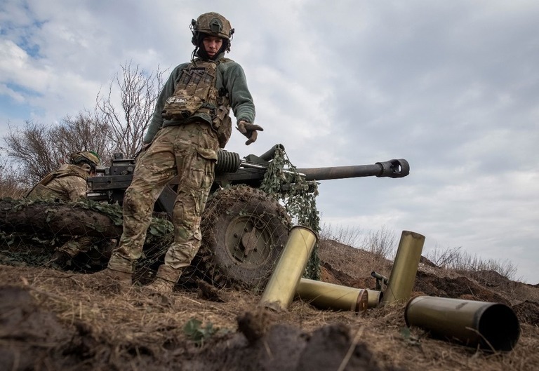 バフムート近くの前線で榴弾砲を発射するウクライナ軍の兵士/Oleksandr Ratushniak/Reuters)