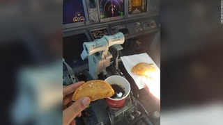 コーヒーや菓子が操縦レバーのすぐ近くに置かれた様子をとらえた写真