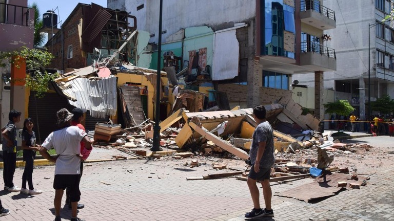 地震で損壊した建物を眺める人々/Jhonny Crespo/AP
