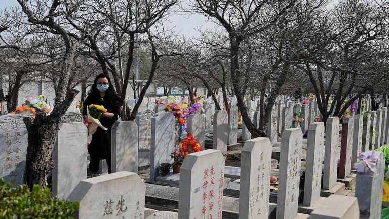 花を手に、北京の墓地へ参拝に訪れた女性/Noel Celis/AFP/Getty Images/FILE