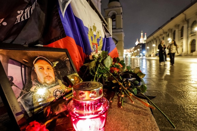 爆発で死亡したタタルスキー氏の肖像写真の前を通り過ぎる人たち/Maxim Shemetov/Reuters