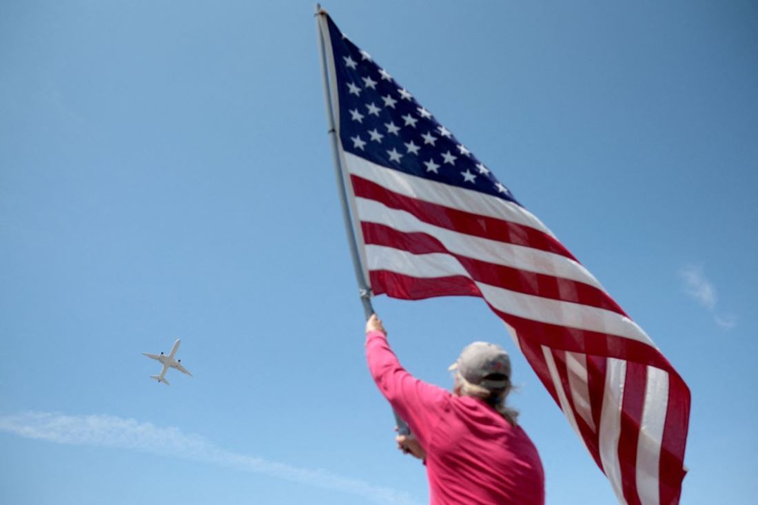 トランプ氏を乗せた旅客機がパームビーチ国際空港を離陸。国旗を振る人の姿も＝３日/Ricardo Arduengo/Reuters
