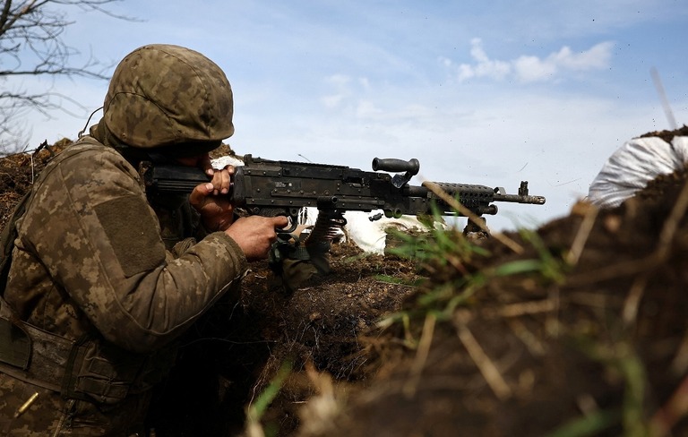 バフムートの前線の塹壕から銃を撃つウクライナ軍兵士＝５日/Kai Pfaffenbach/Reuters