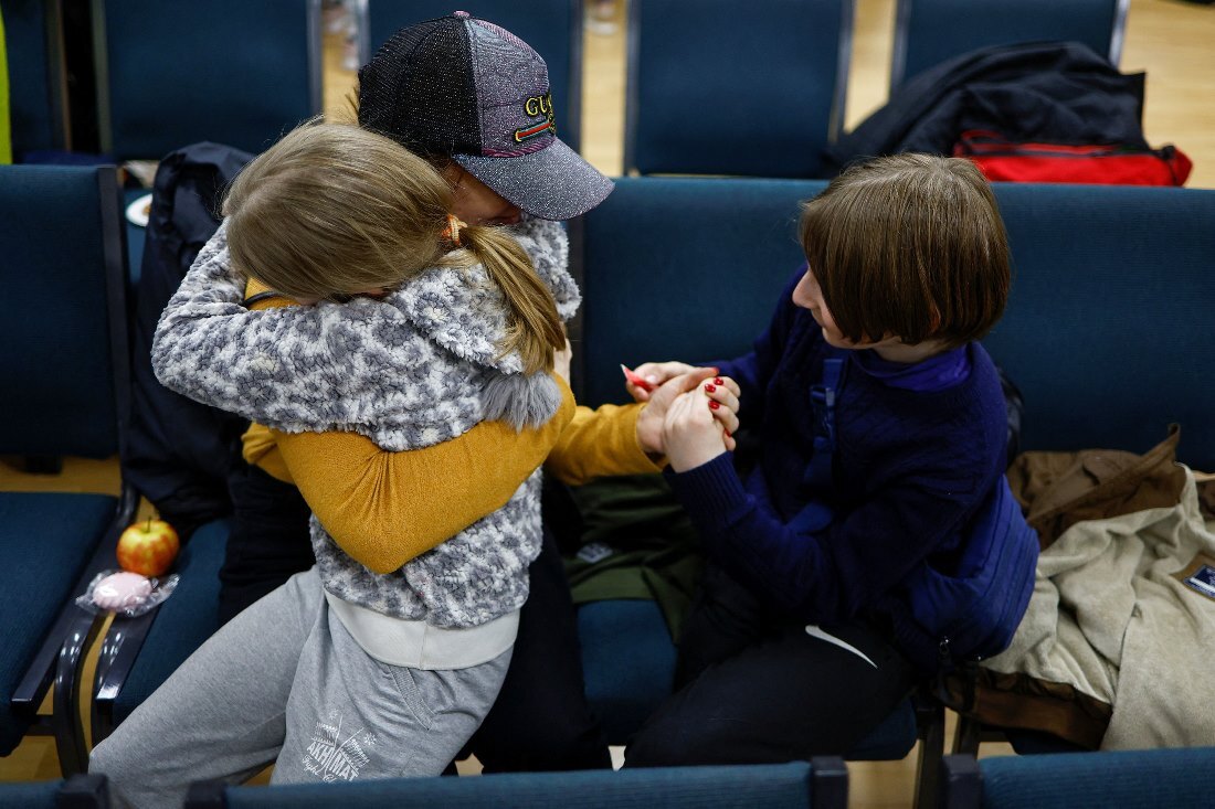 娘を抱きしめ、息子の手を握る母親＝８日、ウクライナ・キーウ/Valentyn Ogirenko/Reuters