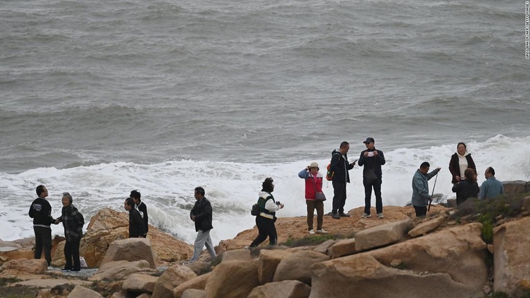 中国福建省東岸沖に浮かぶ平潭島の沿岸部に立つ観光客ら/Greg Baker/AFP/Getty Images