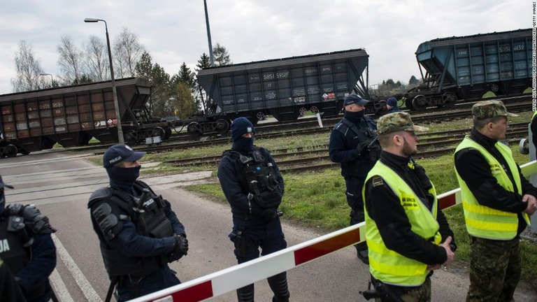 ウクライナ産穀物を載せた貨物列車を警護する警官ら＝１２日、ポーランド/Attila Husejnow/SOPA Images/LightRocket/Getty Images