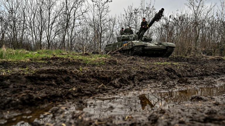 前線近くの演習場で戦車の上に立つウクライナ軍の兵士/Reuters