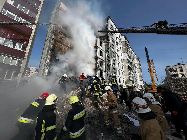ロシアのミサイル攻撃で破壊されたウマニの建物で捜索活動を行うレスキュー隊員ら/State Emergency Service of Ukraine/Reuters