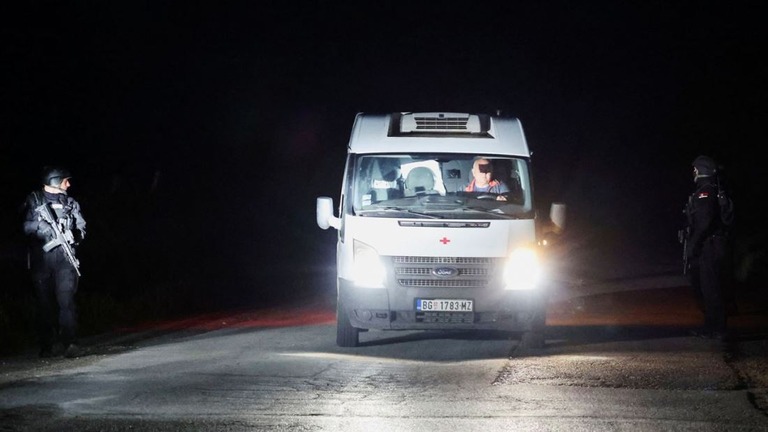 デュボナ村での銃乱射の後、検問所を通過する救急車両/Antonio Bronic/Reuters