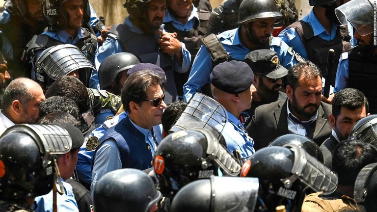 釈放についての聴聞会に出席するため、警官隊に囲まれながら高裁に入るカーン前首相/Aamir Qureshi/AFP/Getty Images