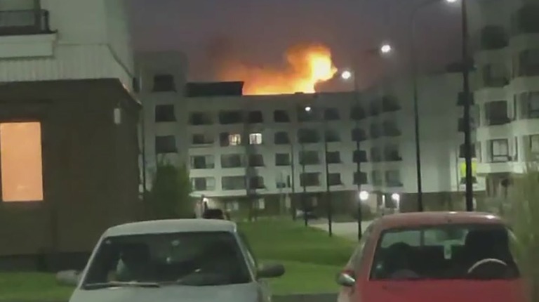 マリウポリ市議会が共有した動画の画像。建物の向こうで炎が上がる様子が見える/Mariupol City Council