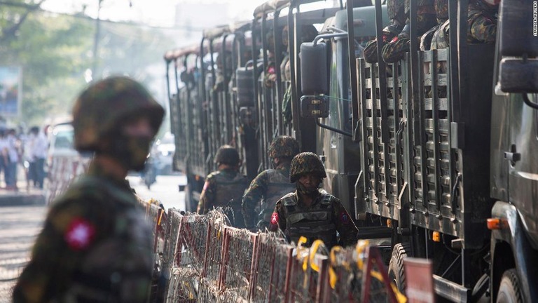 軍用車両の横に立つ兵士＝２０２１年、ミャンマー・ヤンゴン/Stringer/Reuters