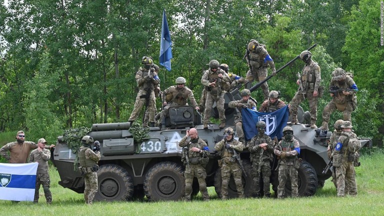 鹵獲したロシア軍の走行車両に集まった、ウクライナ側で戦うロシア人の兵士ら/Sergey Bobok/AFP/Getty Images