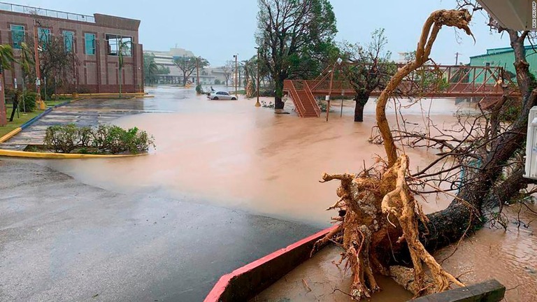 付近で氾濫した川の水が流れ込み冠水した駐車場＝２５日、米領グアム/Rick Cruz/AP