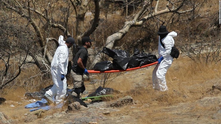 遺体の入った袋を運ぶ法医学の専門家ら＝５月３１日、メキシコ・サポパン/Ulises Ruiz/AFP/Getty Images